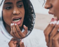 Woman Looking At Her Teeth In The Mirrow