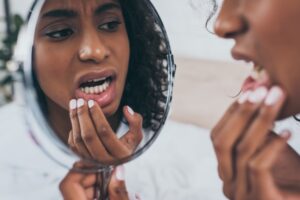 Woman Looking At Her Teeth In The Mirrow